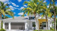 Modern Florida home with palm trees and clear skies.