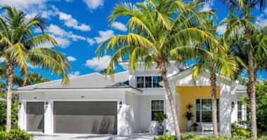 Modern Florida home with palm trees and clear skies.